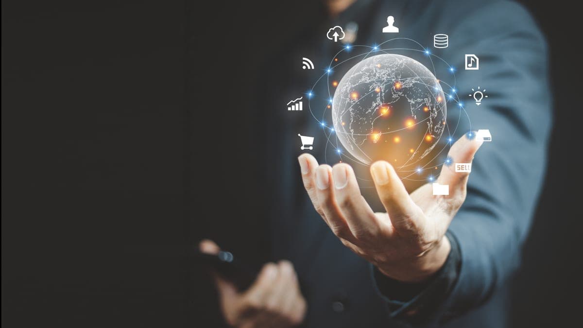 Geschäftsmann hält einen leuchtenden digitalen Globus mit umkreisenden Technologie-Symbolen, Sinnbild für KI-Dienste und Kontosicherheit