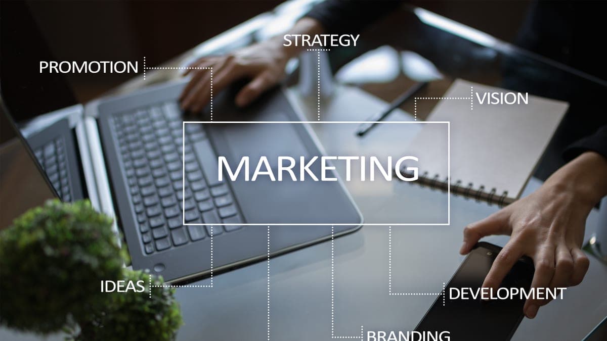 Marketing-Begriffe wie Strategy und Branding schweben über einem Büro-Arbeitsplatz, Sinnbild für den eigenen Web-Auftritt